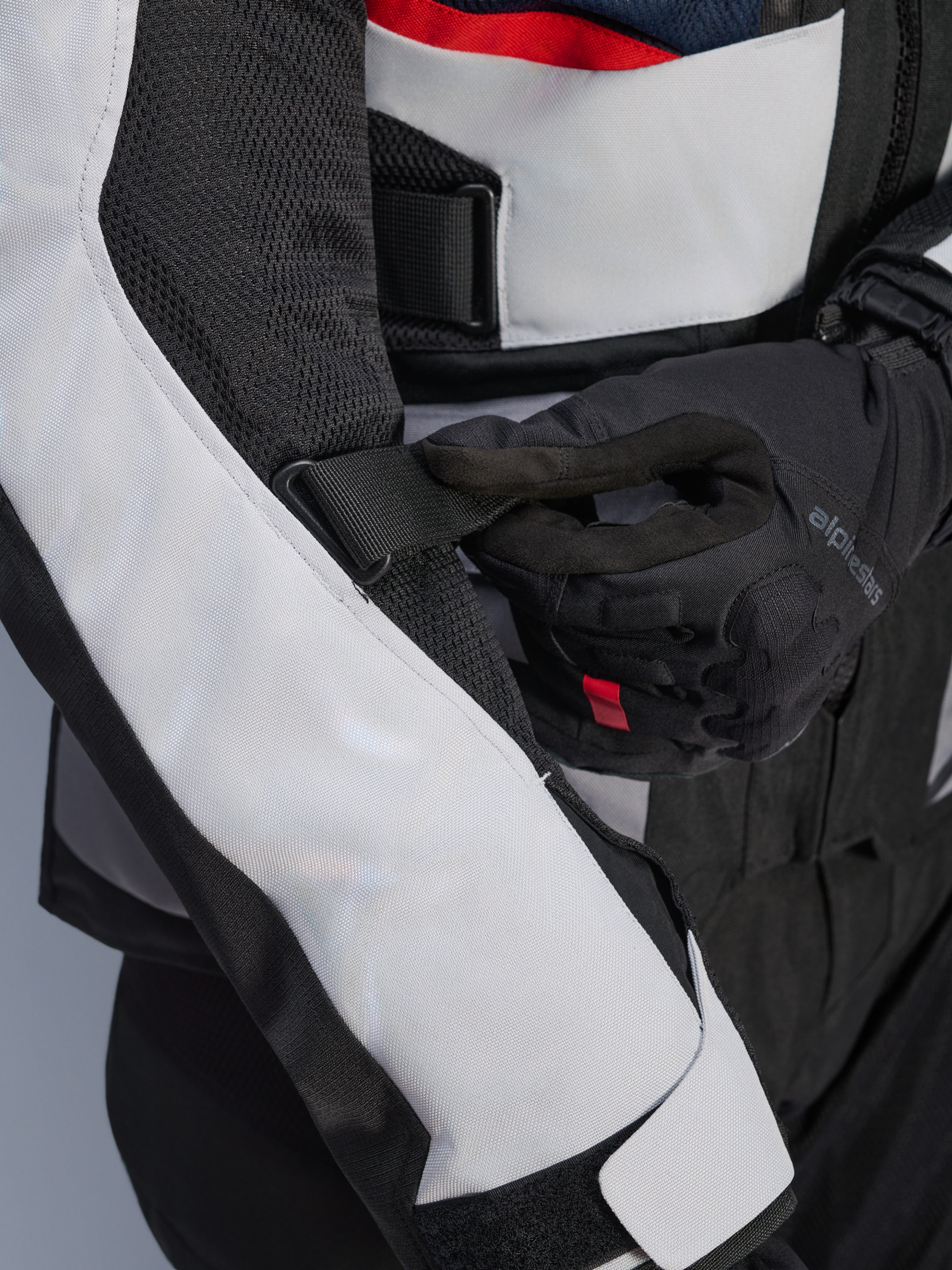 Alpinestars Andes Air Drystar® Jacket in Deep Blue Black Ice Gray, vista ravvicinata della cinghia regolabile sulla manica e dei pannelli di ventilazione in rete, resistente costruzione in tessuto per l'adventure touring