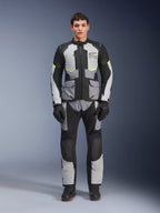Pantaloni Alpinestars Andes Air Drystar®, pantaloni da moto adventure touring, grigio ghiaccio e nero con dettagli giallo neon, vista a figura intera su un modello che indossa giacca e guanti abbinati, design in tessuto con pannelli di ventilazione in mesh