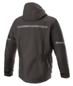 Alpinestars Sirius Drystar® Techshell Jacket, giacca da moto, Nero Melange, vista posteriore con cappuccio integrato, striscia riflettente con logo Alpinestars, vita elasticizzata e parte posteriore allungata per una maggiore copertura durante la guida.