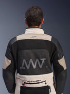 Vista posteriore della giacca Alpinestars AMT-10LAB Drystar® XF in White Sand e nero, con un grande logo AMT sul pannello posteriore in rete, marchio Alpinestars sulla parte bassa della schiena e costruzione in tessuto tecnico per il motociclismo adventure