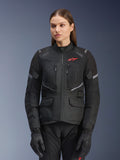 Alpinestars Stella Andes Air Drystar Jacket, giacca da moto touring da donna, nera con dettagli grigi e un piccolo logo rosso, con pannelli di ventilazione in rete, collo alto e diverse tasche utility, indossata con guanti e pantaloni coordinati
