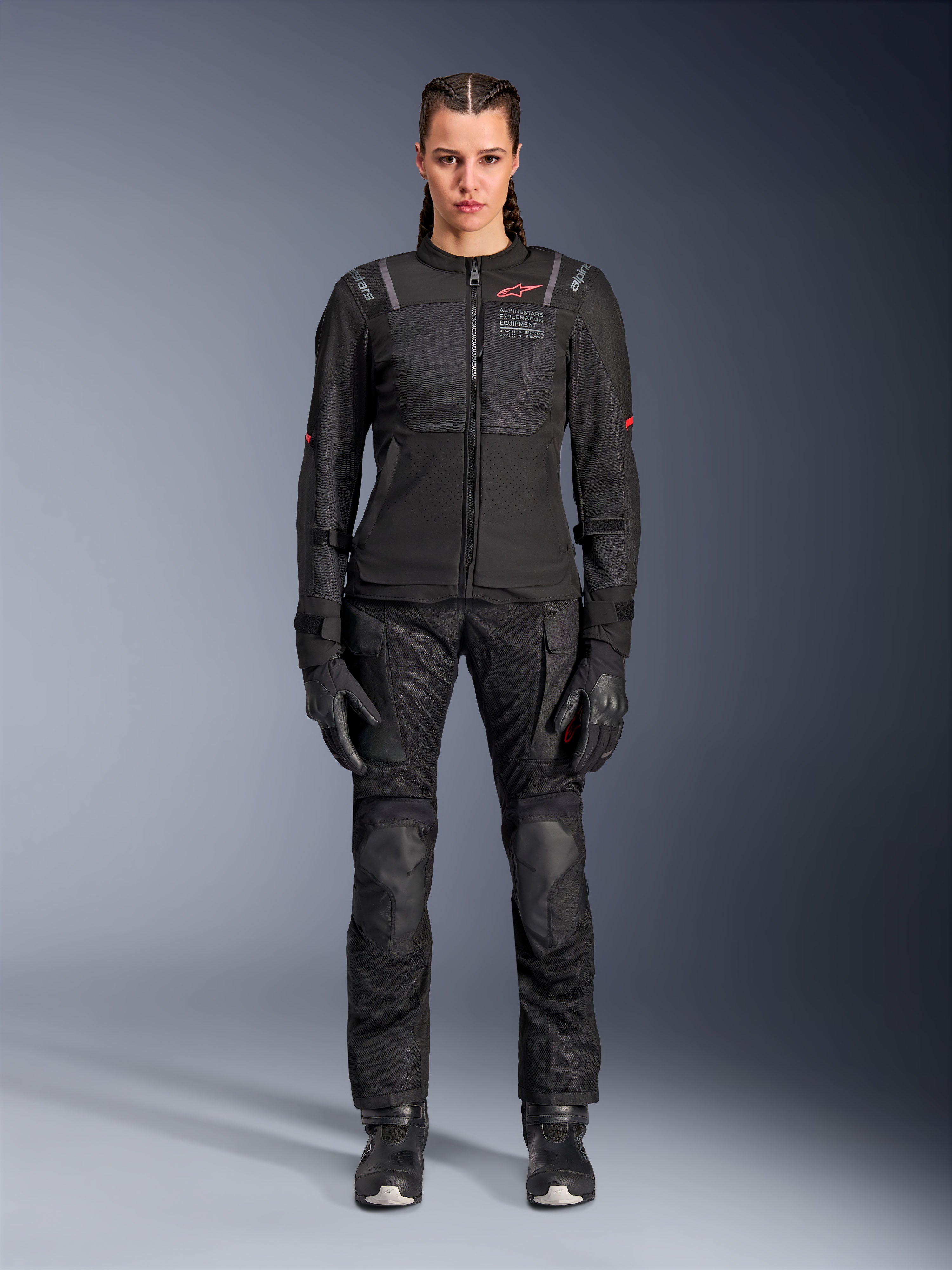 Giacca Alpinestars Stella ST-2 Air, nera, vista a figura intera in studio di una motociclista con pantaloni e guanti da moto neri abbinati, pannelli in mesh ad alta ventilazione, dettagli del logo rossi e design touring moderno