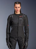 Giacca Alpinestars Stella ST-2 Air da donna, giacca da moto, nera, vista frontale su modella, con pannelli in mesh, logo rosso sul petto e marchio Alpinestars Exploration Equipment, indossata con guanti neri e pantaloni tecnici