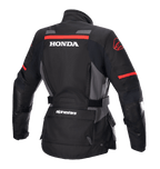 Alpinestars Giacca Stella Honda Andes V3 Drystar® da donna, giacca da moto adventure, nero, grigio catrame e rosso acceso, vista posteriore con logo HONDA bianco e grafiche Alpinestars rosse, costruzione in tessuto impermeabile con vita regolabile e tasche portaoggetti