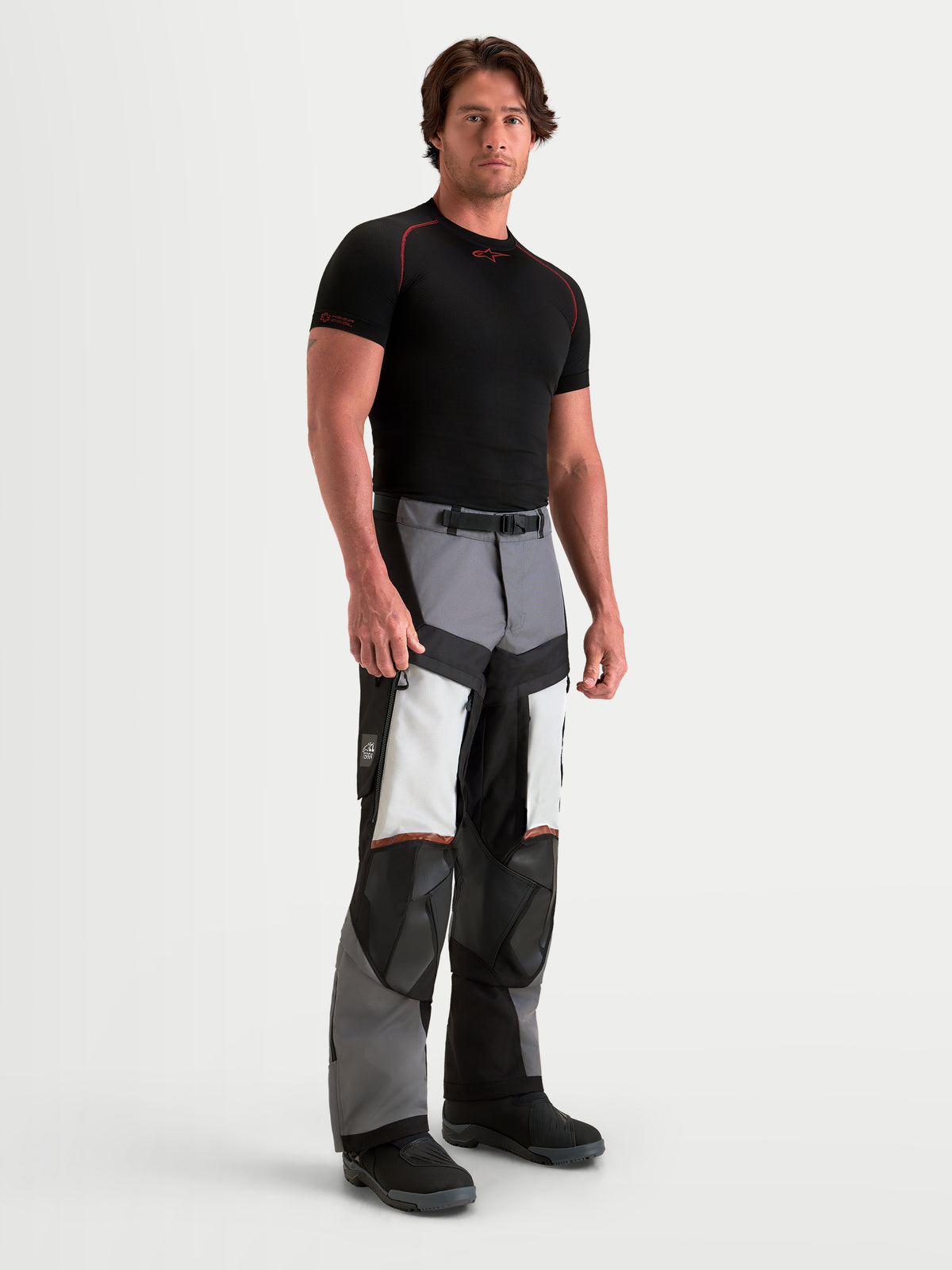 Alpinestars Harok V2 Drystar Pantaloni, pantaloni da moto adventure da uomo, grigio scuro, grigio ghiaccio e nero, con struttura in ripstop resistente e prese d'aria sulle cosce, indossati da un modello in studio