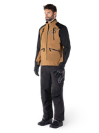 Alpinestars Hyde XT Drystar® Pants, pantaloni da moto adventure, nero, indossati con giacca tecnica marrone e nera, guanti e stivali neri, caratterizzati da un design sopra lo stivale per la guida off-road e dual-sport