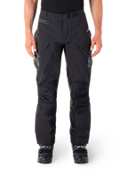 Pantaloni Alpinestars Hyde XT Drystar, pantaloni adventure touring neri, indossati da un pilota con stivali neri, con loghi grigi sulle cosce, cintura integrata, pannelli rinforzati sulle ginocchia e costruzione in tessuto impermeabile