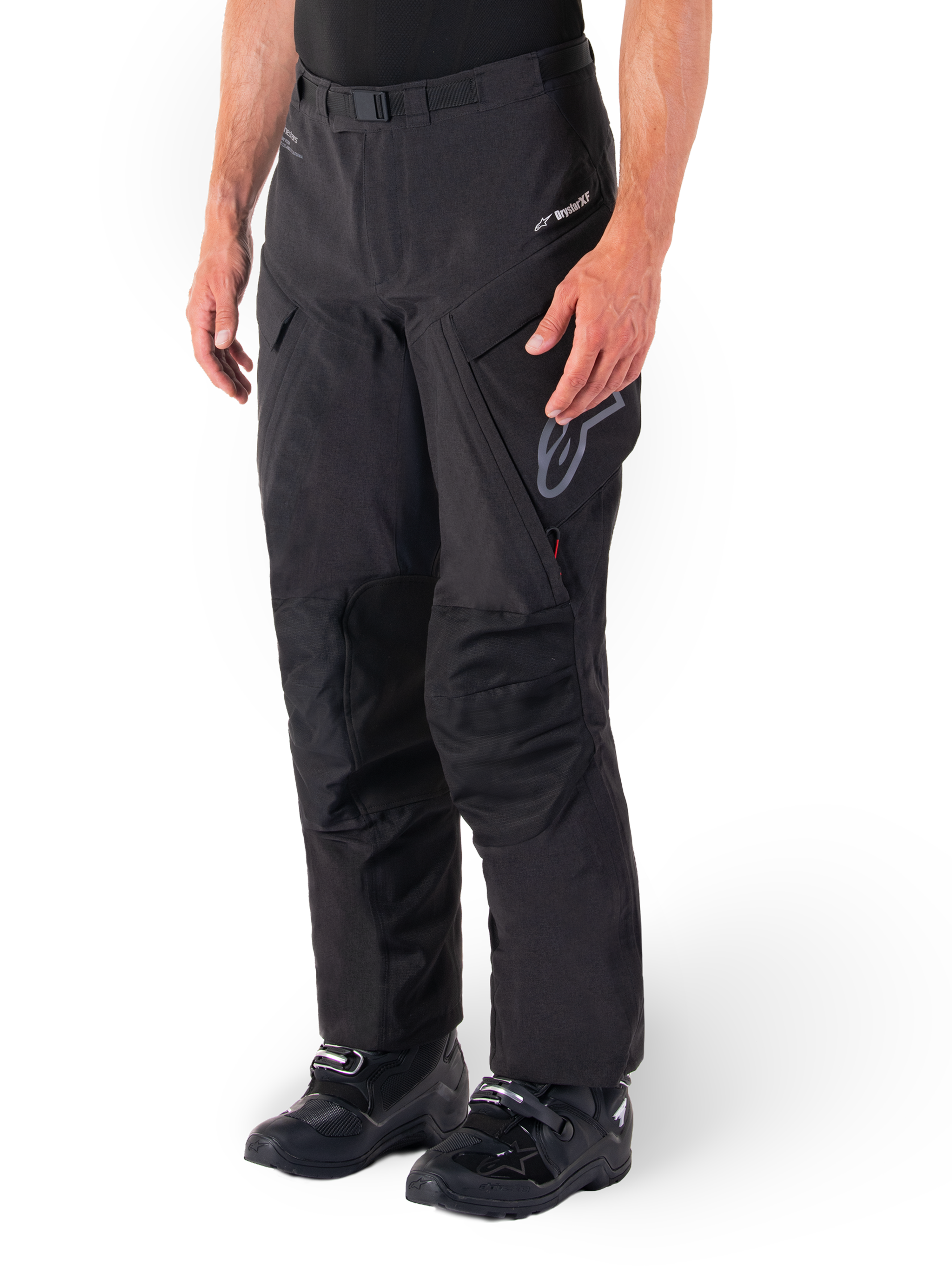 Alpinestars Hyde XT Drystar® Pants, pantaloni da moto adventure touring, nero, indossati con stivali neri, con logo della membrana laminata Drystar®XF, pannelli rinforzati sulle ginocchia e tasche cargo con zip