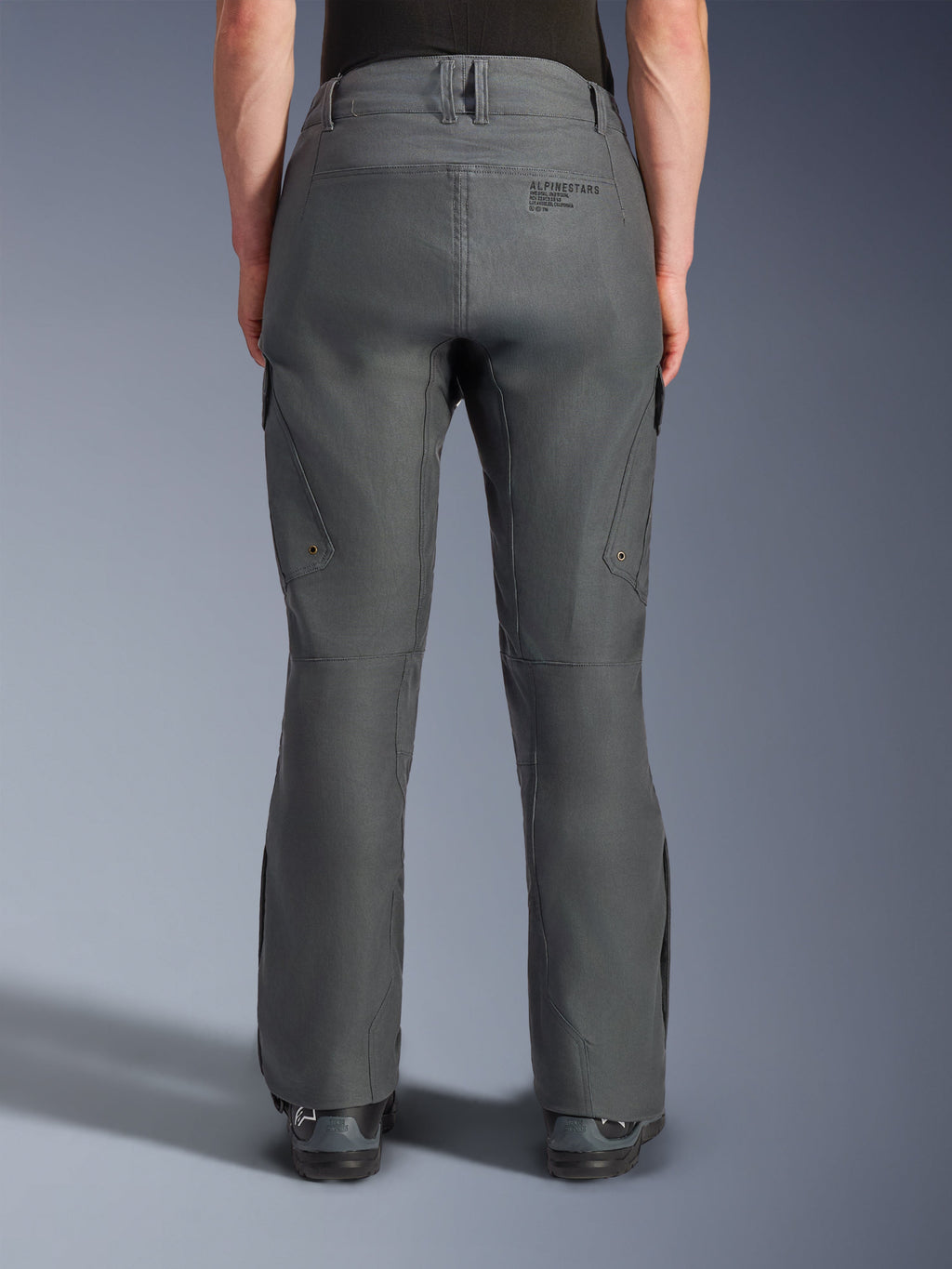 Pantaloni Alpinestars Borrego Drystar®, pantaloni da moto adventure, grigio antracite, vista posteriore che mostra la costruzione in tessuto con aspetto tela cerata, branding Alpinestars sul retro, tasche cargo e passanti per cintura, design robusto e resistente per la guida adventure