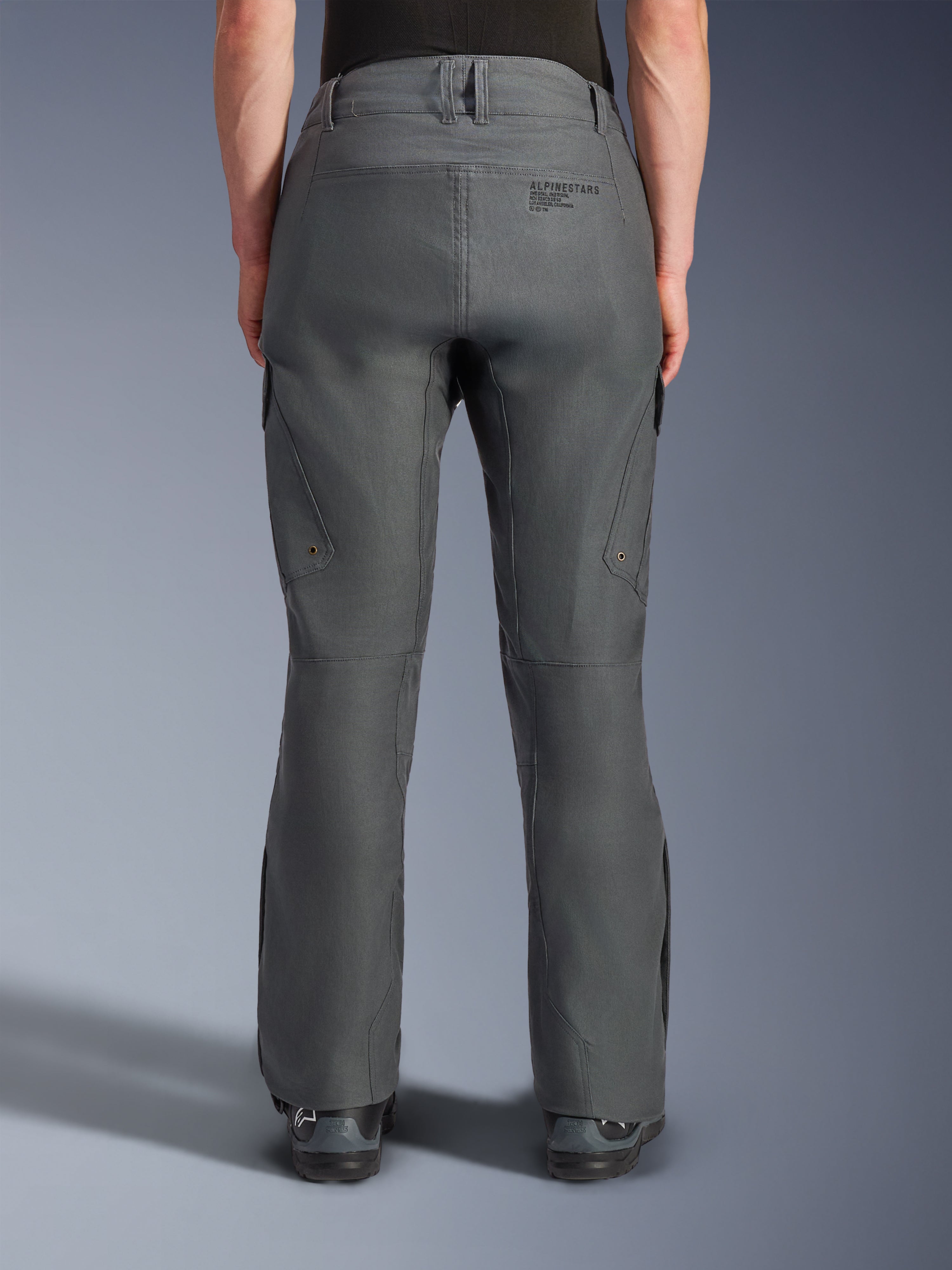 Pantaloni Alpinestars Borrego Drystar®, pantaloni da moto adventure, grigio antracite, vista posteriore che mostra la costruzione in tessuto con aspetto tela cerata, branding Alpinestars sul retro, tasche cargo e passanti per cintura, design robusto e resistente per la guida adventure