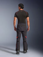 Alpinestars Halo Pro Drystar® XF Laminated Pants, pantaloni da moto adventure, Black Dark Shadow con accenti rossi, vista posteriore indossati con base layer nero a maniche corte e stivali adventure neri, costruzione laminata a 3 strati e vestibilità ergonomica