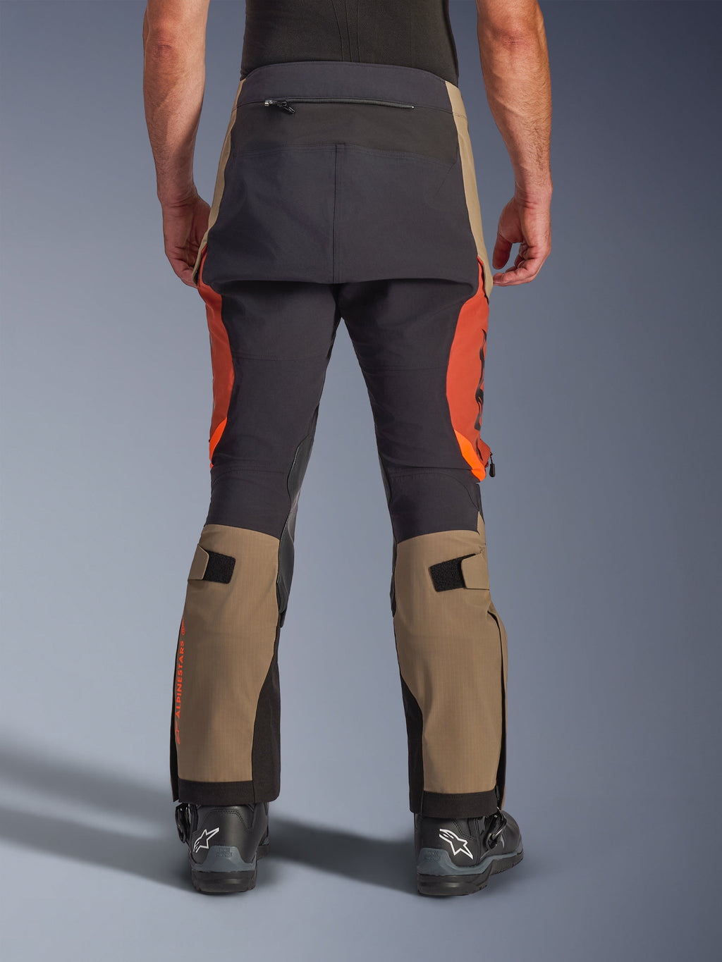 Pantaloni laminati Alpinestars Halo Pro Drystar® XF in Walnut Rust Black, vista posteriore, pantaloni da moto adventure con pannelli noce e arancione ruggine e rinforzo nero sulla seduta, con tasca posteriore con zip e cinturini regolabili sui polpacci
