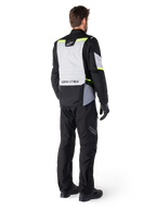 Alpinestars ST-1 Waterproof Pants, Black, rear view on a rider paired with a matching adventure touring jacket featuring gray and fluorescent yellow accents, worn with black boots and gloves, coordinated outfit for all-weather road and adventure riding