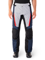 Alpinestars ST-1 Waterproof Pants, pantaloni da moto touring, blu scuro e grigio chiaro con dettagli rosso acceso, pannelli neri rinforzati sulle ginocchia, vista frontale con stivali neri, abbigliamento impermeabile per adventure touring