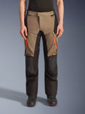 Alpinestars Andes V4 Drystar® Pants, pantaloni da moto adventure touring, marrone e nero, con cerniere arancioni brillanti sulle cosce, pannelli neri rinforzati sulle ginocchia e robusta struttura in tessuto per ogni condizione climatica.