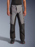 Alpinestars Andes V4 Drystar® Pants, pantaloni da moto adventure touring, grigio e nero, vista frontale indossati da un modello con stivali da guida neri, caratterizzati da rinforzi sulle ginocchia e tasche cargo sulle cosce, costruzione in tessuto impermeabile e traspirante per tutte le condizioni atmosferiche