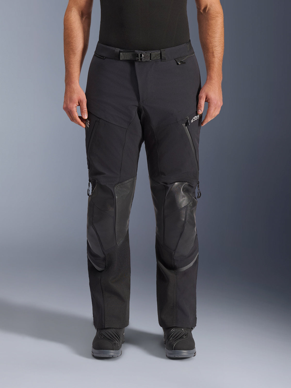 Alpinestars Andes Pro Drystar® XF Pants, pantaloni da moto adventure touring, Black Dark Gray, vista frontale, costruzione laminata a 3 strati, pannelli di protezione per le ginocchia, tasche impermeabili con zip e fibbia magnetica, indossati con stivali neri