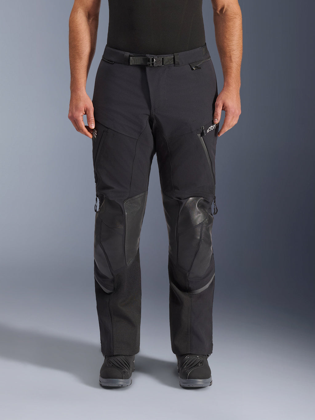 Alpinestars Andes Pro Drystar® XF Pants, pantaloni da moto adventure touring, Black Dark Gray, vista frontale, costruzione laminata a 3 strati, pannelli di protezione per le ginocchia, tasche impermeabili con zip e fibbia magnetica, indossati con stivali neri