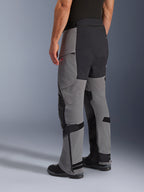 Pantaloni Alpinestars Andes Pro Drystar® XF, pantaloni da moto adventure, grigio scuro e nero, vista posteriore di tre quarti, struttura in tessuto con rinforzi neri su seduta e interno gamba, fondo gamba con cerniera e linguette regolabili