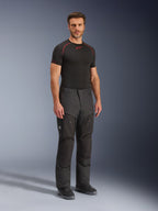 Pantaloni Alpinestars Cusco Drystar®, pantaloni da moto in tessuto nero, indossati da un modello con base layer nero e stivali, caratterizzati da tessuto ripstop, ampie tasche cargo con marchio 'Terra' e design ergonomico per la guida adventure.
