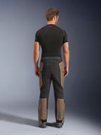 Alpinestars Pantaloni Cusco Drystar®, pantaloni da moto adventure, Walnut Black, vista posteriore con pannelli marroni e neri, robusta costruzione in ripstop, indossati con una maglia tecnica nera