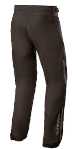Alpinestars AST-1 V2 Waterproof Pants, pantaloni da moto in tessuto, nero, vista posteriore-laterale con dettagli riflettenti, logo Alpinestars sulla parte inferiore della gamba, cerniera di connessione in vita e fondo gamba regolabile per protezione in tutte le condizioni atmosferiche