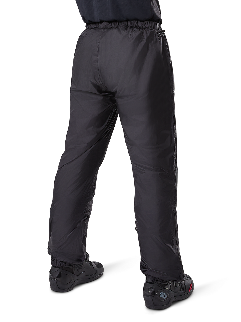 Alpinestars Bogota' Pro Drystar® 3 Seasons Pants, pantaloni da moto adventure touring neri, vista posteriore della fodera impermeabile Drystar® indossata come sovrapantaloni, abbinati a stivali da moto neri, costruzione tecnica leggera per protezione multi-stagione