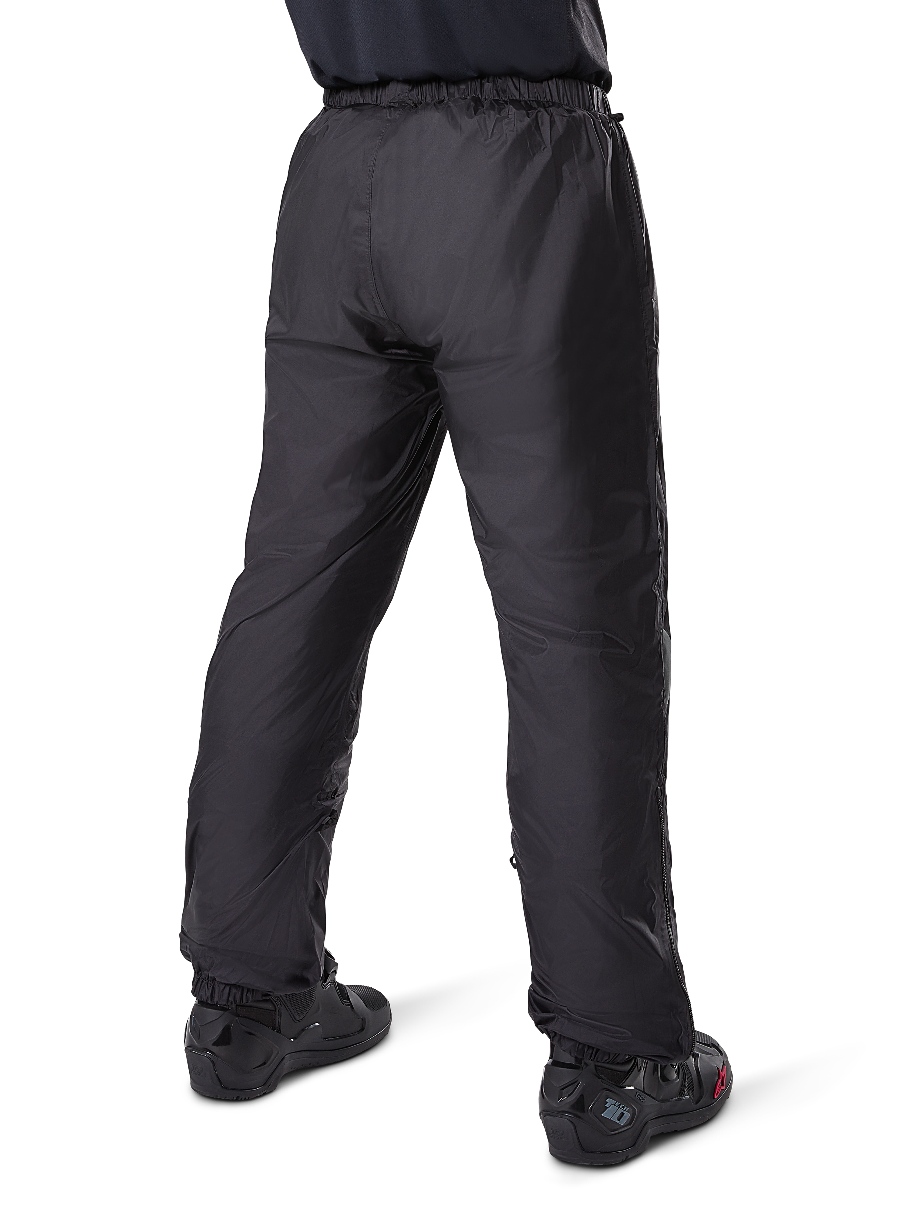 Alpinestars Bogota' Pro Drystar® 3 Seasons Pants, pantaloni da moto adventure touring neri, vista posteriore della fodera impermeabile Drystar® indossata come sovrapantaloni, abbinati a stivali da moto neri, costruzione tecnica leggera per protezione multi-stagione