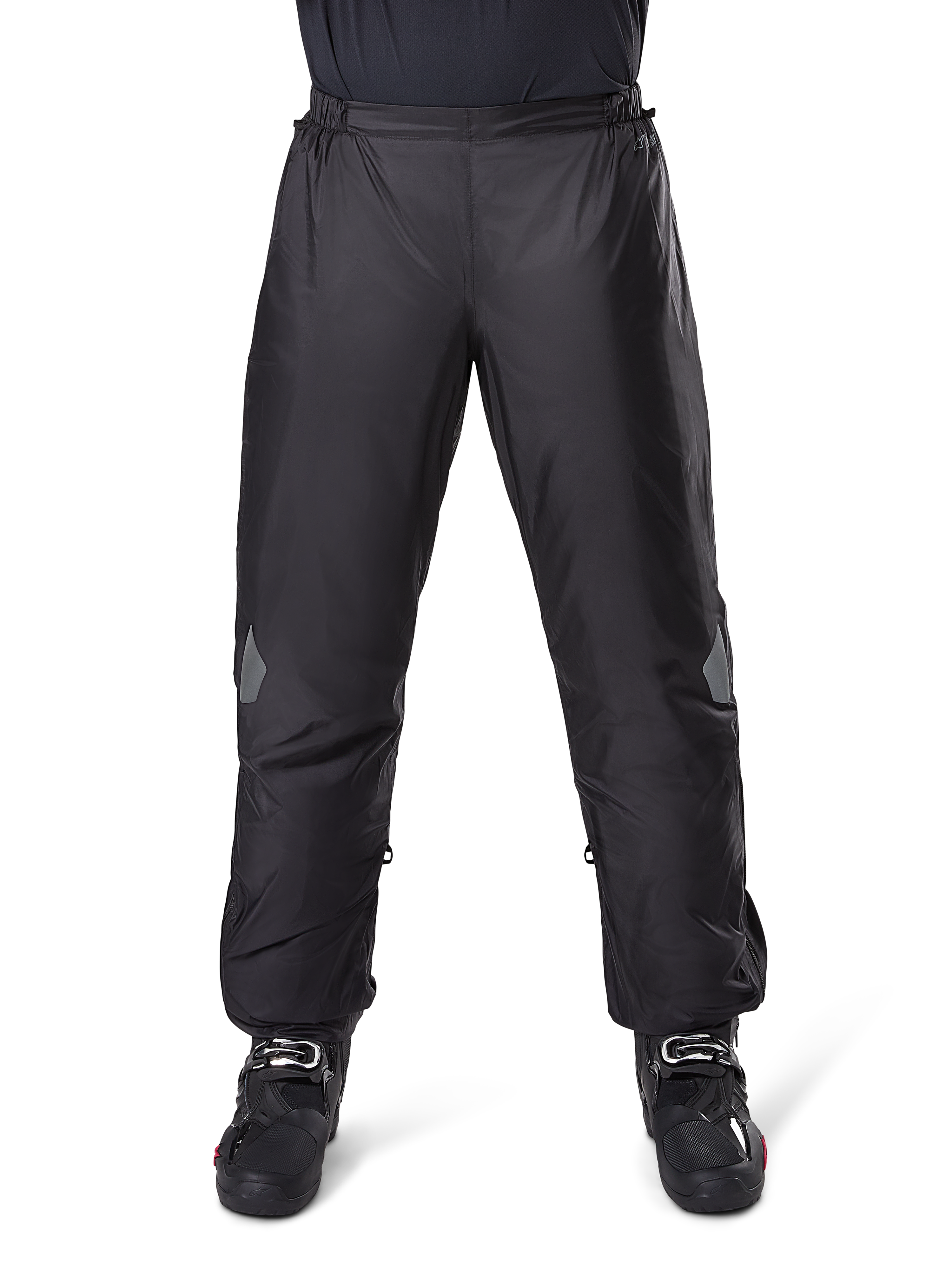 Alpinestars Bogota Pro Drystar 3 Seasons Pants, pantaloni da moto impermeabili, nero, tessuto tecnico leggero con inserti riflettenti sulle ginocchia, indossati come sovrapantaloni con stivali da moto neri, progettati per protezione adventure touring