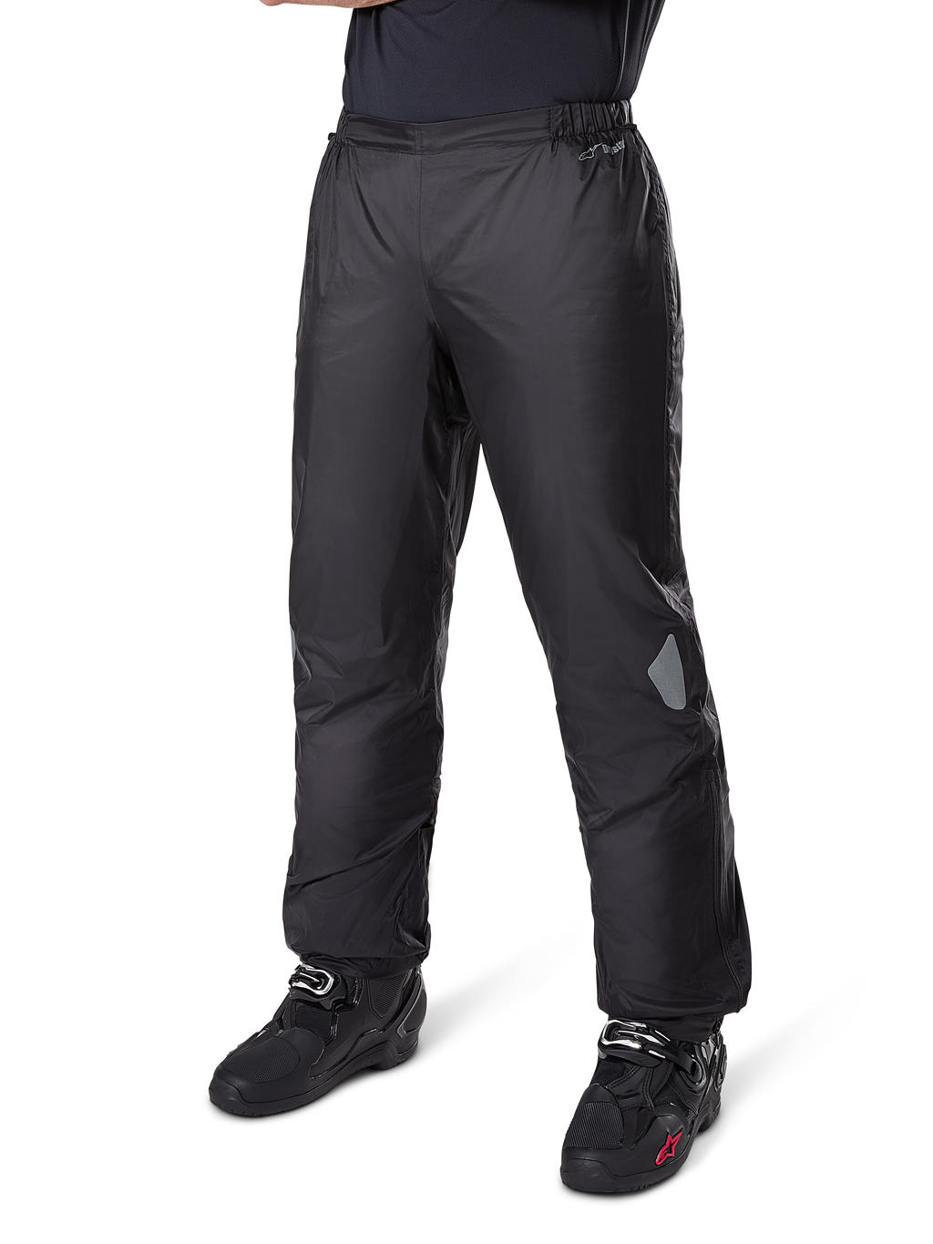 Pantaloni Alpinestars Bogotá Pro Drystar® 3 Seasons, pantaloni da moto adventure touring, nero, indossati con stivali da moto neri, con inserti riflettenti sulle ginocchia e marchio Drystar, design in tessuto leggero e impermeabile per la guida in ogni stagione.