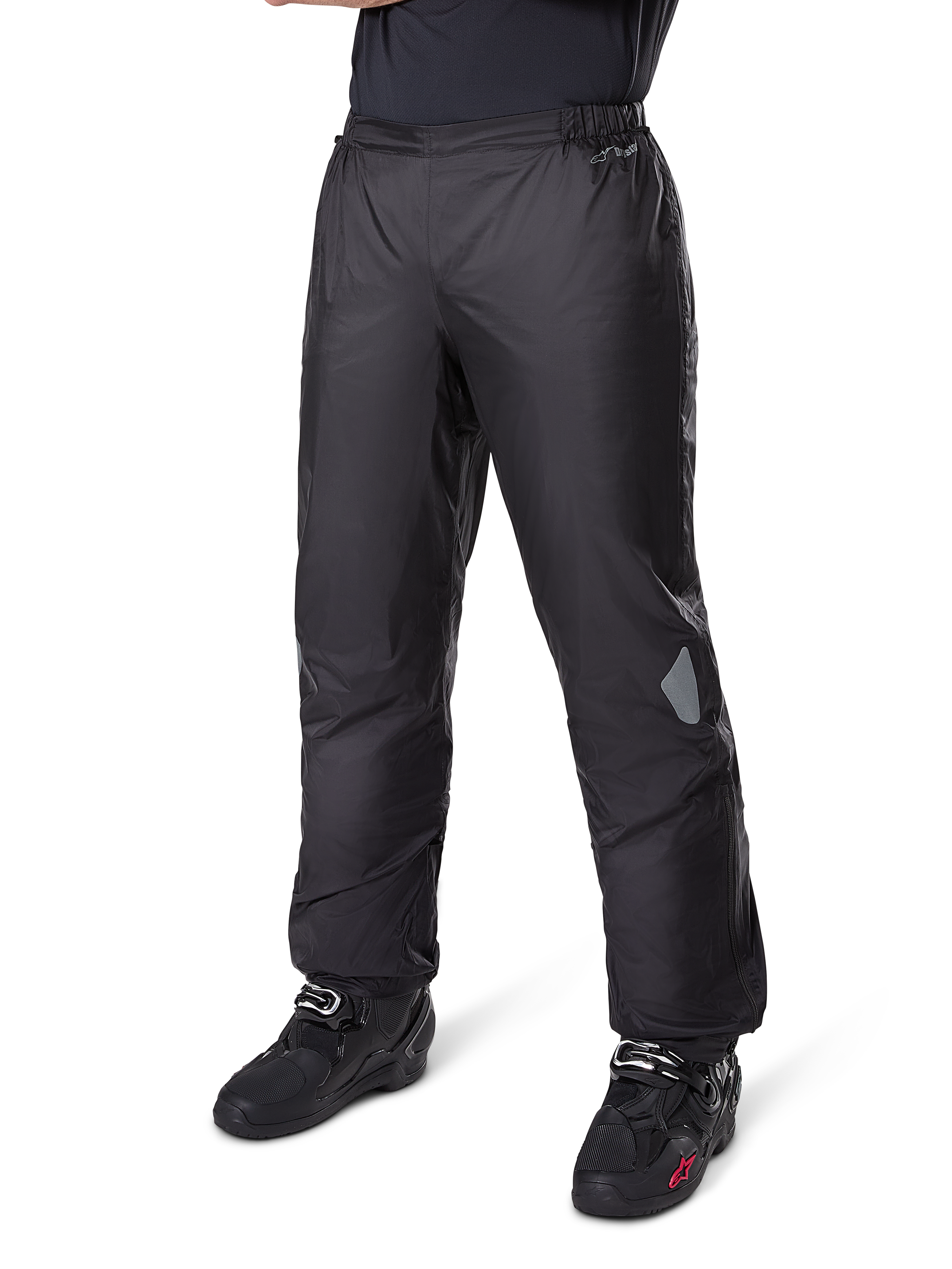 Pantaloni Alpinestars Bogotá Pro Drystar® 3 Seasons, pantaloni da moto adventure touring, nero, indossati con stivali da moto neri, con inserti riflettenti sulle ginocchia e marchio Drystar, design in tessuto leggero e impermeabile per la guida in ogni stagione.