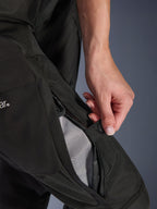 Alpinestars Pantaloni Stella Andes V4 Drystar® da donna, pantaloni da moto, nero, primo piano di una mano che apre la ventilazione con zip sulla coscia per rivelare la fodera in rete per il flusso d'aria, abbigliamento adventure in tessuto resistente
