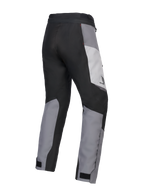 Alpinestars 2025 Honda Stella ST-1 Waterproof Pants, pantaloni da moto touring da donna, Ice Gray, Grigio Scuro e Nero, vista posteriore a tre quarti che mostra la costruzione in tessuto resistente, pannelli color-block grigi e neri, marchio Honda sul fianco e chiusure regolabili alle caviglie.