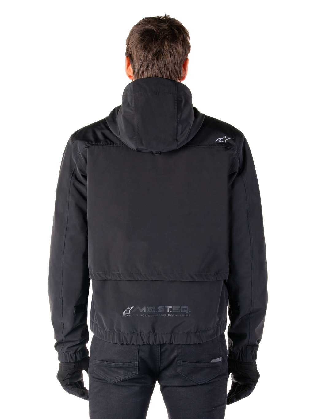Alpinestars Mootant Waterproof Parka, giacca da moto nera, vista posteriore con cappuccio, piccolo logo Astar sulla spalla e marchio riflettente MO.ST.EQ. sulla parte bassa della schiena