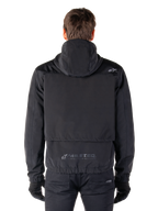Alpinestars Mootant Waterproof Parka, giacca da moto nera, vista posteriore con cappuccio, piccolo logo Astar sulla spalla e marchio riflettente MO.ST.EQ. sulla parte bassa della schiena
