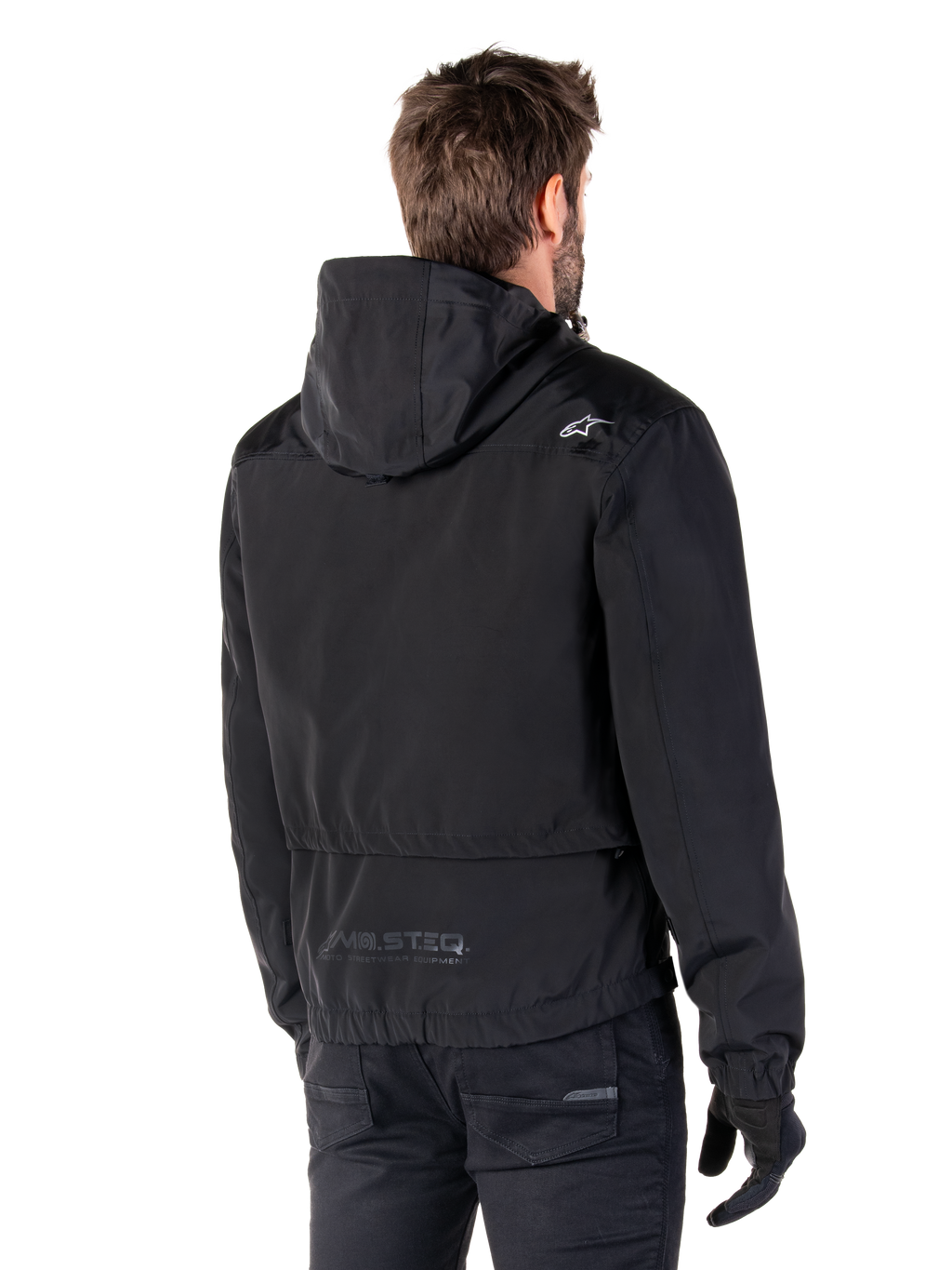 Alpinestars Mootant Waterproof Parka, giacca da moto nera, vista posteriore con design con cappuccio, logo bianco sulla spalla e marchio riflettente MO.ST.EQ. sulla parte bassa della schiena, abbigliamento tecnico urban contemporary