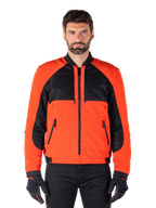 Alpinestars Mootant Waterproof Parka in Spicy Orange e nero, giacca da moto modulare mostrata in configurazione stile bomber su un modello maschile, con pannelli in rete nera sulla parte superiore del torace, busto e maniche arancione acceso, cerniera frontale e colletto a costine, abbinata a guanti e pantaloni neri