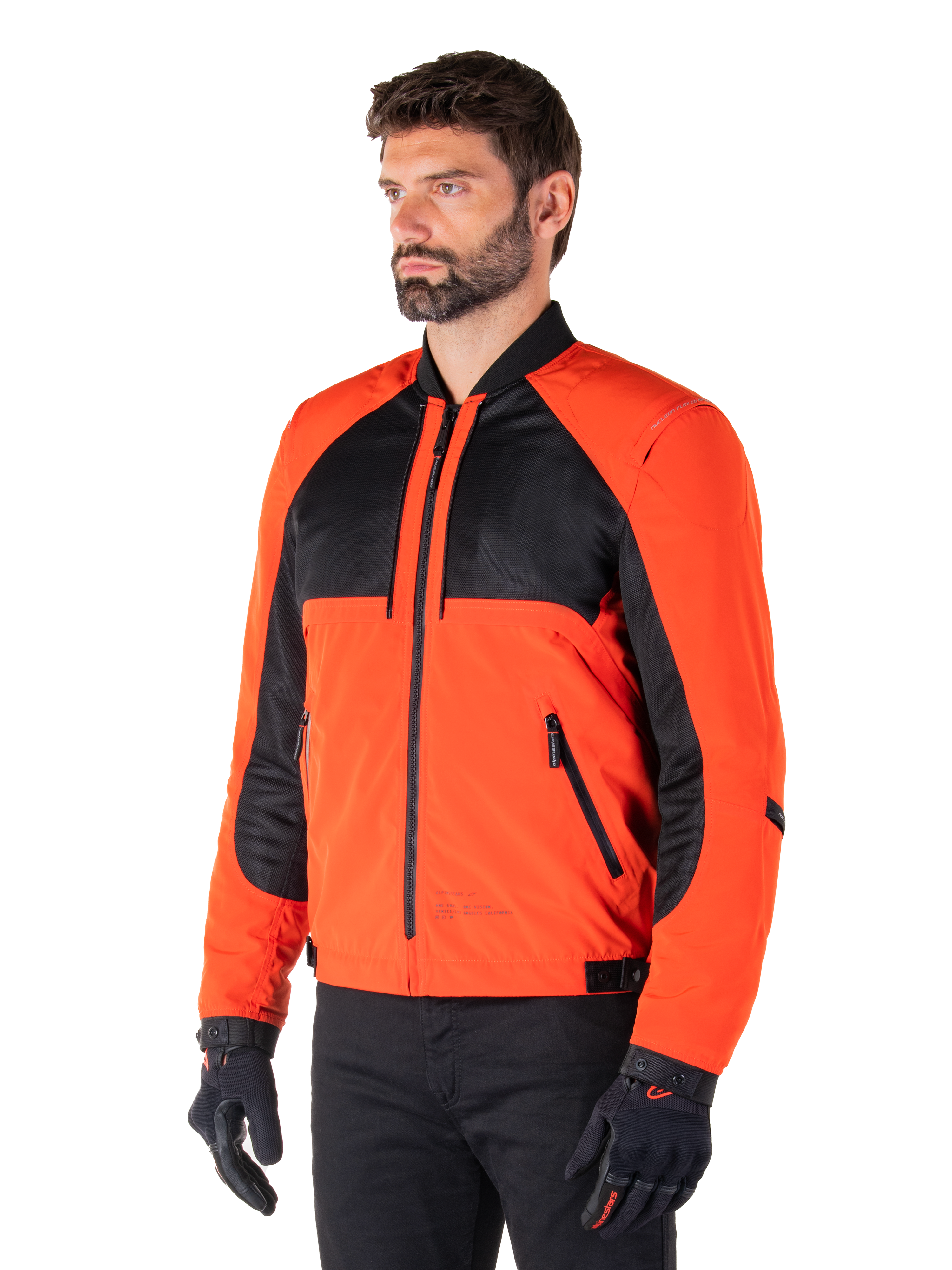 Alpinestars Mootant Waterproof Parka in Spicy Orange e nero, giacca da moto modulare mostrata nella sua configurazione bomber, presenta pannelli in mesh nero e tessuto arancione, abbigliamento tecnico urbano contemporaneo indossato con guanti neri