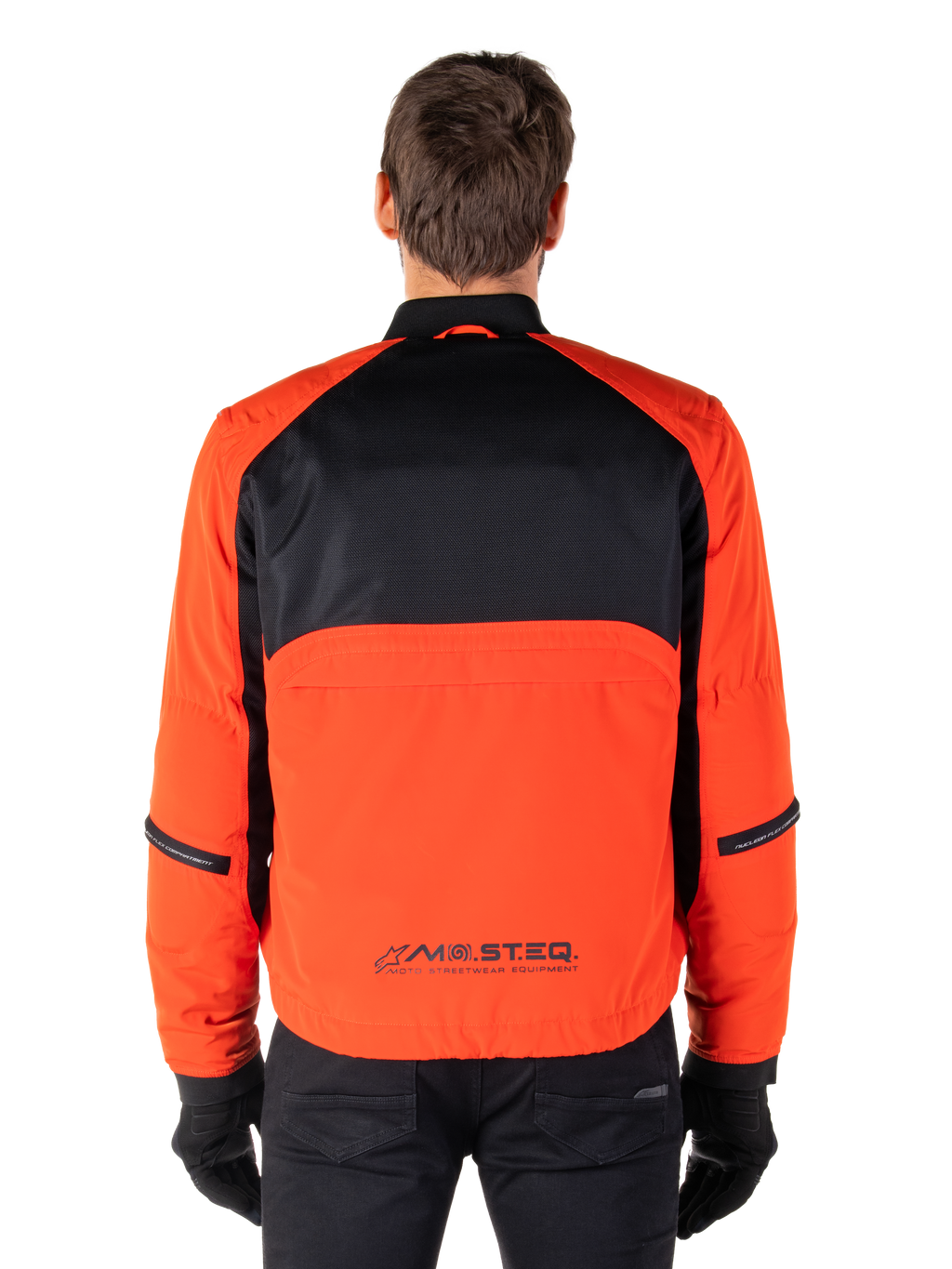 Alpinestars Parka impermeabile Mootant, giacca da moto, arancione e nero, vista posteriore, con parte superiore della schiena in mesh nero e pannello inferiore arancione con logo MO.ST.EQ., indossato con pantaloni e guanti neri