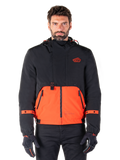 Alpinestars Mootant Waterproof Parka, giacca da moto modulare in Spicy Orange e nero, indossata da un modello con guanti coordinati, design con cappuccio e pannelli bicolore, cerniera frontale e polsini regolabili, abbigliamento tecnico urbano contemporaneo