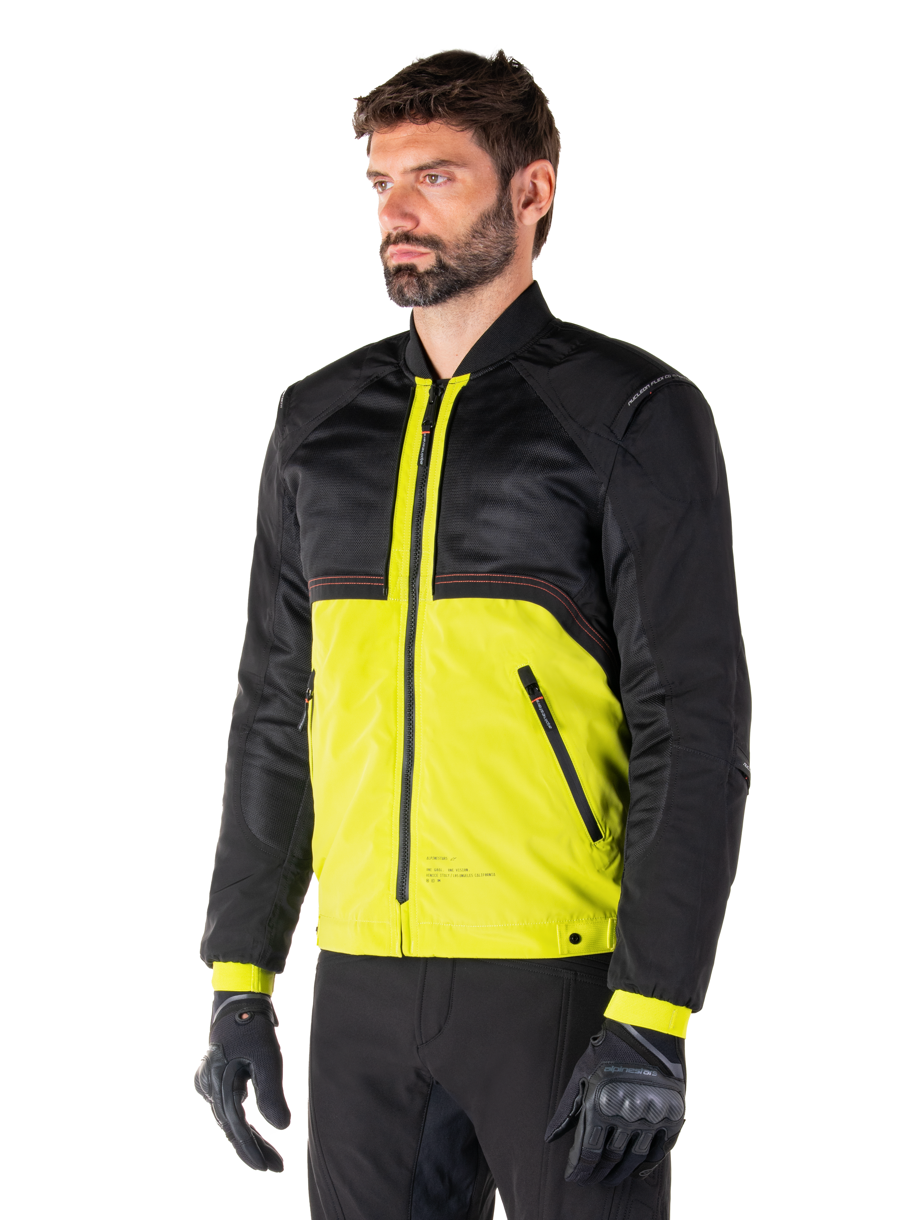 Alpinestars Mootant Waterproof Parka in Lime Punch Black, giacca da moto modulare con parte superiore in rete nera e parte inferiore verde lime vivace, indossata da un motociclista con guanti e pantaloni neri, stile di guida urbano contemporaneo