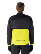 Alpinestars Mootant Waterproof Parka, giacca da moto, Lime Punch e nero, vista posteriore con parte superiore in rete nera per la ventilazione e sezione inferiore lime con logo MO.ST.EQ., indossata con pantaloni e guanti neri