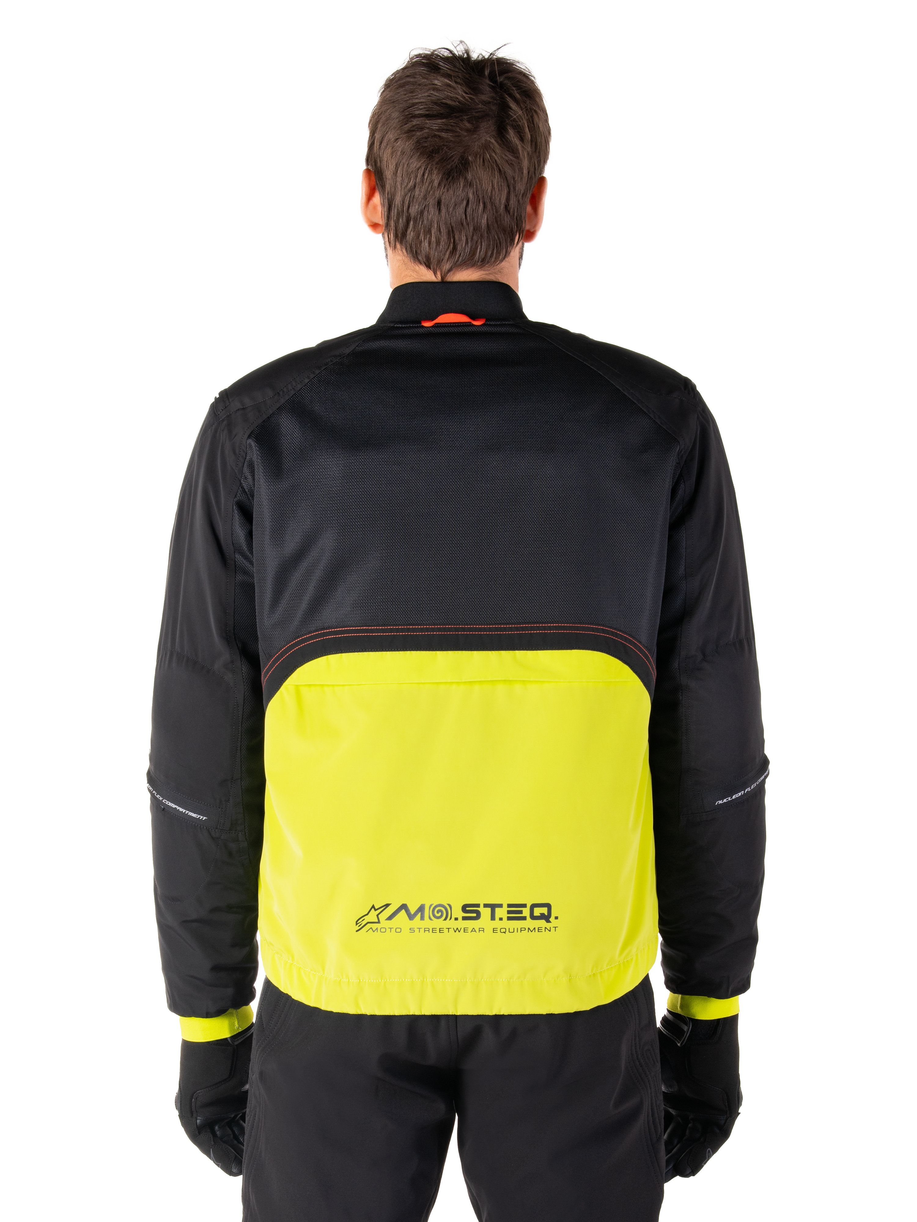 Alpinestars Mootant Waterproof Parka, giacca da moto, Lime Punch e nero, vista posteriore con parte superiore in rete nera per la ventilazione e sezione inferiore lime con logo MO.ST.EQ., indossata con pantaloni e guanti neri
