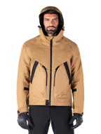 Alpinestars Morush Waterproof Parka, giacca da moto, marrone utility, design con cappuccio ispirato allo streetwear con ampie tasche anteriori con accenti neri, indossata con guanti da moto e pantaloni neri, abbigliamento moto urban contemporary