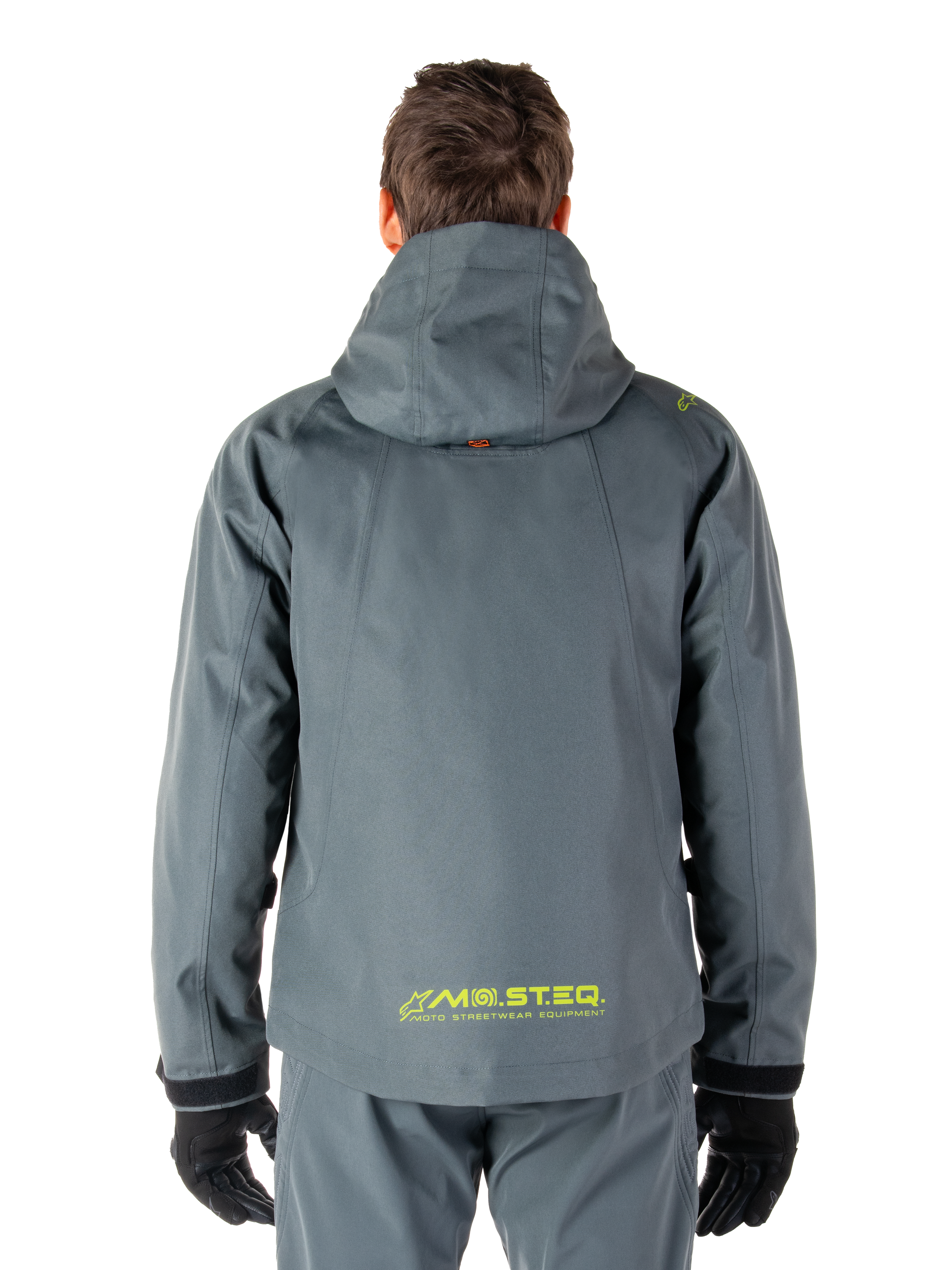Alpinestars Morush Waterproof Parka, giacca da moto, Urban Gray, vista posteriore che mostra il design con cappuccio e il logo giallo MO.ST.EQ. sulla parte inferiore della schiena, abbigliamento da moto moderno ispirato allo streetwear urbano