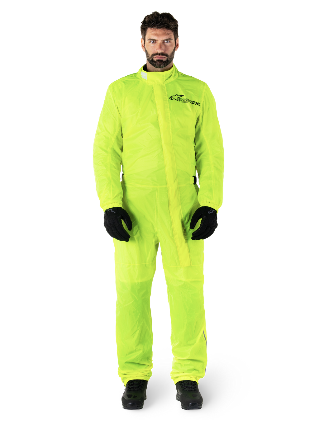 Alpinestars Hurricane Rain V2 Suit, tuta antipioggia da moto, giallo fluo, modello che indossa protezione integrale con guanti e stivali neri, colletto alto con patta antipioggia frontale, logo riflettente sul petto, abbigliamento impermeabile ad alta visibilità