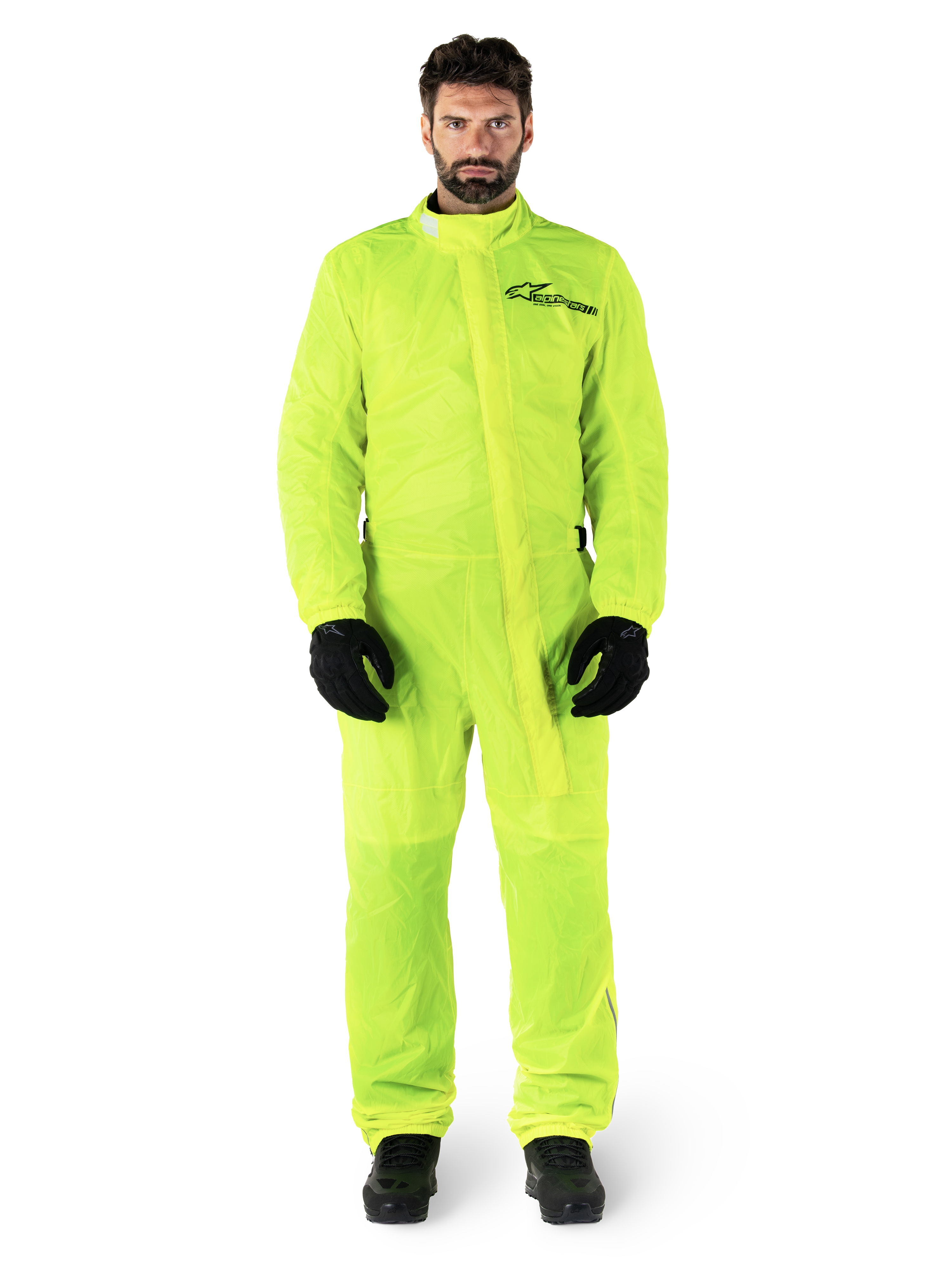Alpinestars Hurricane Rain V2 Suit, tuta antipioggia da moto, giallo fluo, modello che indossa protezione integrale con guanti e stivali neri, colletto alto con patta antipioggia frontale, logo riflettente sul petto, abbigliamento impermeabile ad alta visibilità
