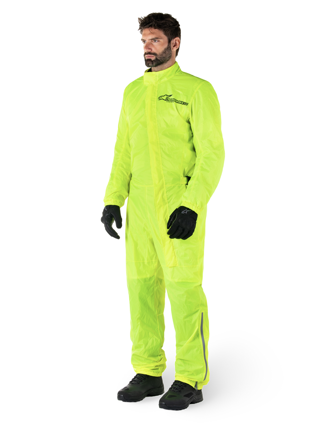 Alpinestars Hurricane Rain V2 Suit, tuta da moto impermeabile monopezzo, Giallo Fluo, indossata con guanti e stivali neri, con logo Alpinestars nero sul petto e dettagli riflettenti sulle gambe