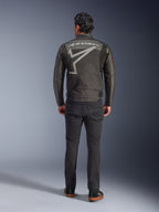 Giacca Alpinestars Axton, giacca da moto, Nero Antracite Rosso Tangerine, vista posteriore con grande logo Alpinestars grigio e grafica a stella, pannelli a fisarmonica sulle spalle, indossata con pantaloni neri e scarpe casual nere.