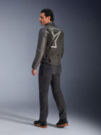 Giacca Alpinestars Axton, giacca da moto da uomo, nero e antracite, vista posteriore con un grande logo grigio avvolgente e pannelli a fisarmonica sulle spalle, indossata con pantaloni da guida scuri e sneakers nere, stile urban contemporaneo con eredità racing